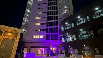 Un grand hôtel à plusieurs étages, doté d’une piscine et d’un hall d’entrée bien éclairé.