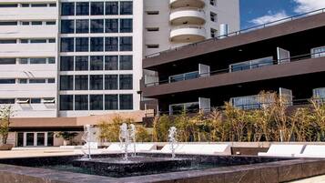 Un edificio moderno con un elemento acuático en primer plano.