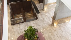 A spacious lobby with a central seating area, a staircase, and a high ceiling.