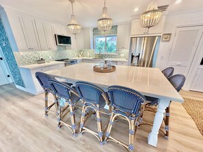 A modern kitchen with a large island, white cabinetry, and a herringbone backsplash. - Little Gasparilla Island: Luxurious Bungalow, Private Beach, Fishing, Family (Placida)