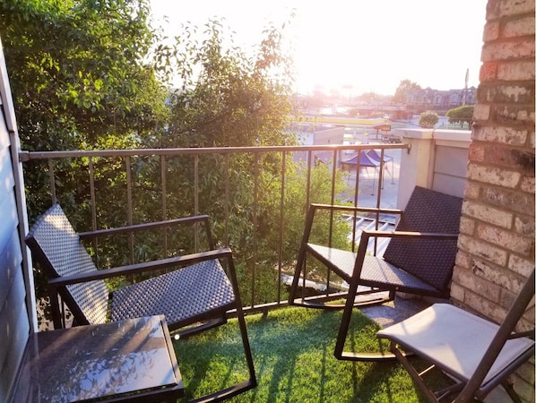 Enjoy the serene view from this balcony with a table and two comfortable chairs.