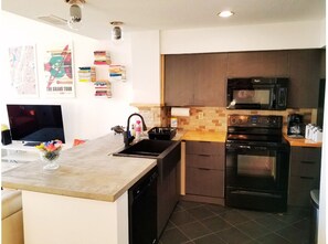 Enjoy cooking in this well-equipped kitchen with a central island, oven, microwave, and coffee maker.