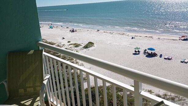 A balcony with a view of a beach.