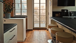 Une cuisine moderne dotée d’une grande fenêtre, d’un plancher en bois et d’un téléviseur encastré.