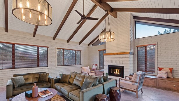 A spacious living room with a sectional sofa, a fireplace, and large windows. - Red Rock Awakening - Spacious Uptown home (Sedona)