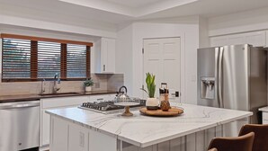 A modern kitchen with a large island, stainless steel appliances, and a water dispenser. - Red Rock Awakening - Spacious Uptown home (Sedona)