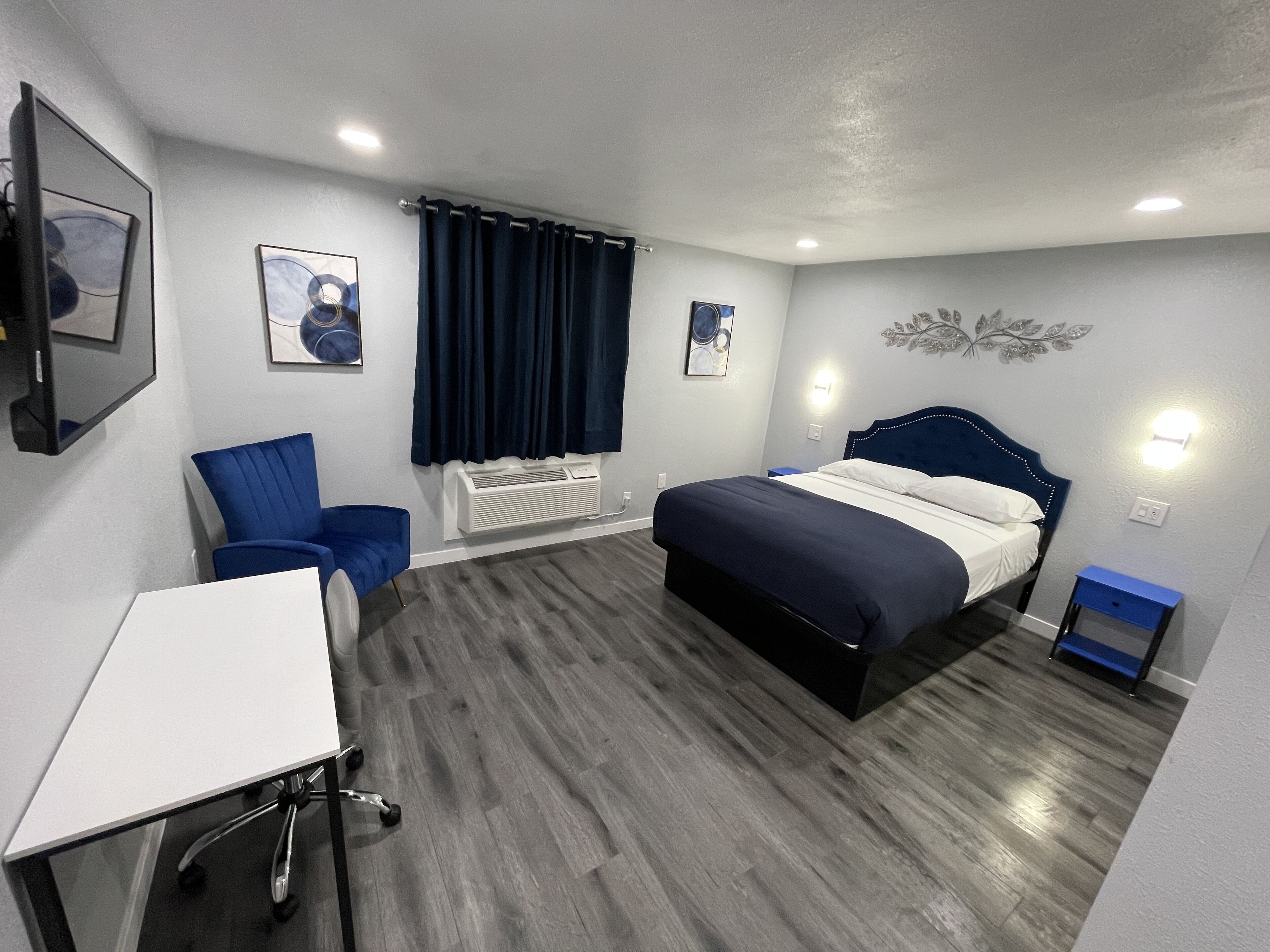 Una habitación de hotel moderna con una cama, un escritorio y una silla.