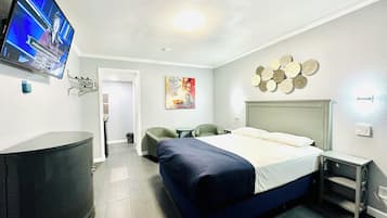 A hotel room with a bed, a television, a desk, and a chair.