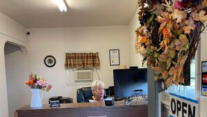 A reception desk with a 'NO SMOKING' sign, a clock, and a window with blinds. - Cadiz Motel by OYO on Route 250 (Cadiz)