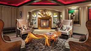 A modern living room with a fireplace, leather armchairs, and a unique wooden coffee table. - Luxury 3-Bedroom Penthouse-style Retreat in Beaver Creek Village (Beaver Creek)