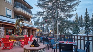An outdoor patio with stone seating, a fire pit, and a statue. - Luxury 3-Bedroom Penthouse-style Retreat in Beaver Creek Village (Beaver Creek)