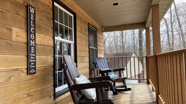 A wooden cabin with a porch, two rocking chairs, and a 'WELCOME' sign. - Cabin. Hocking county ,private , secluded. Family, Friends. (Rockbridge)