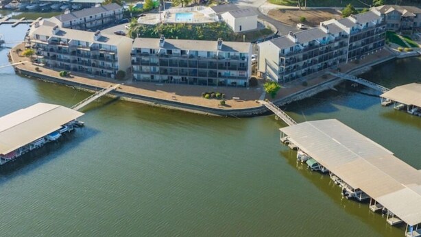 Ein Hotel am Wasserufer mit mehreren Gebäuden, einem Anlegesteg und einer Brücke, die eine Verbindung ans Ufer herstellt.