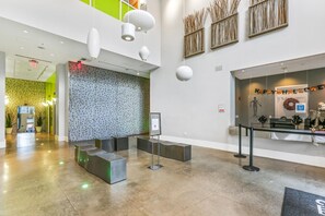 A modern lobby with a reception desk, seating area, and decorative wall art.
