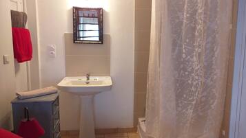 A bathroom with a white sink, a mirror, and a shower curtain.