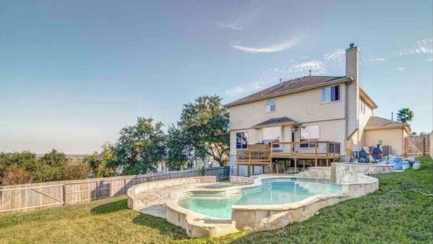 Uma casa de dois andares com piscina no quintal.