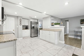 Enjoy cooking in this well-equipped kitchen with a central island, stainless steel appliances, and ample cabinetry.