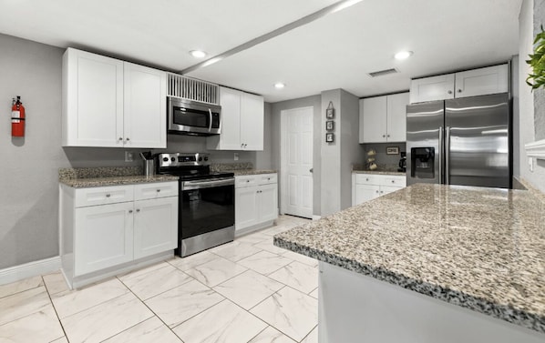 Enjoy cooking in this well-equipped kitchen with oven, microwave, and refrigerator.
