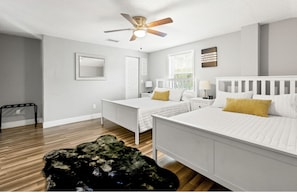 Relax in a serene bedroom with a large bed, nightstand, and ceiling fan.
