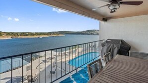 Ein Balkon mit Pool, Gartenmöbeln und Meerblick.