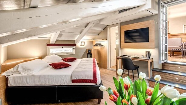 Une chambre à coucher moderne avec un lit, un bureau et un téléviseur.
