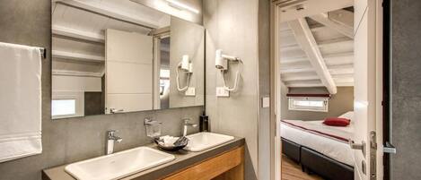 A modern bathroom with two sinks, a large mirror, and a wooden vanity.
