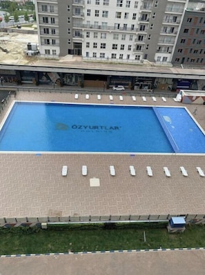 Una piscina con solárium y tumbonas.