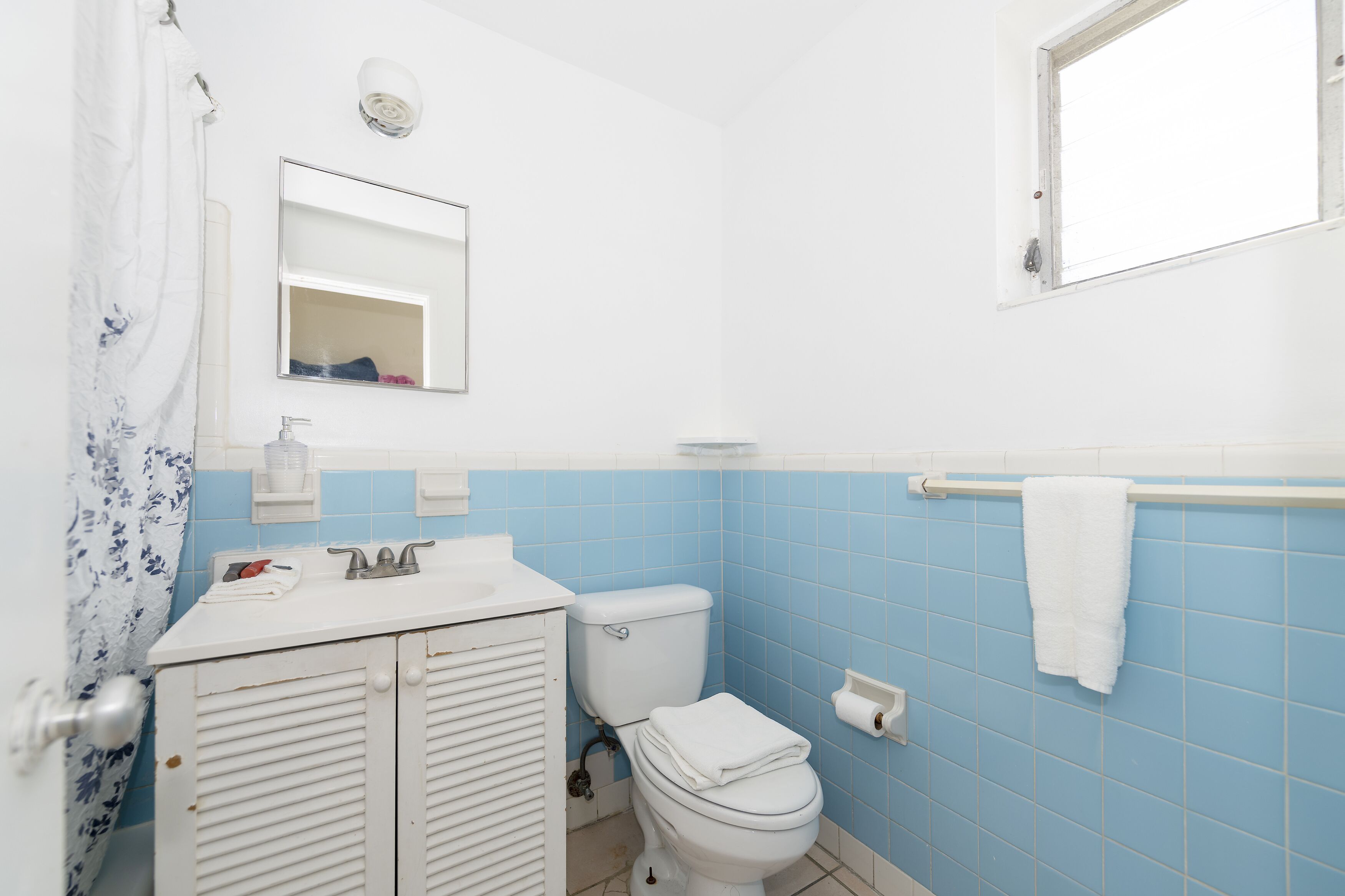 Un baño con inodoro, lavamanos y espejo.