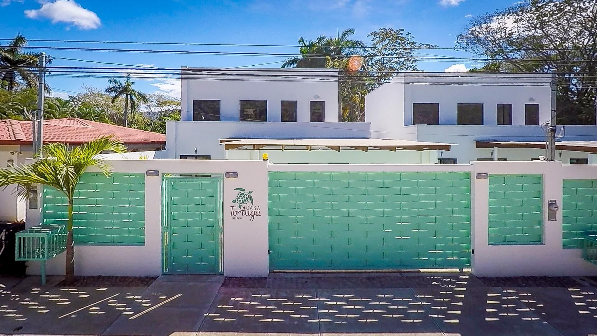 A modern building with a green gate and a sign reading "Casa Portugal."