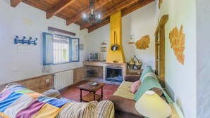 Een gezellige woonkamer met een open haard, een televisie en een bank.