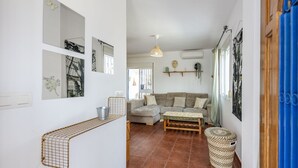 A living room with a sofa, a coffee table, and a hanging light fixture.