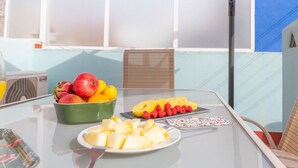 Een tafel met fruit, een fruitschaal en een bord fruit in een kamer met uitzicht.