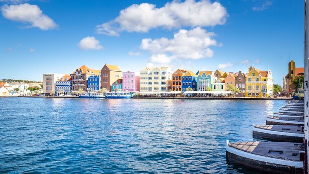 Un muelle con edificios de colores frente al agua.