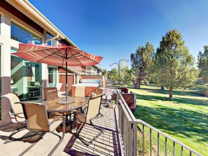 A deck with outdoor furniture, a hot tub, and a view of a grassy area with trees. - Hot Tub, 2 blocks to Splash Pool, Sleeps 8, on the creek (Redmond)