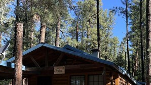 Una cabaña rústica con una terraza de madera y un letrero que dice "EOWBOY'S TRAIL".