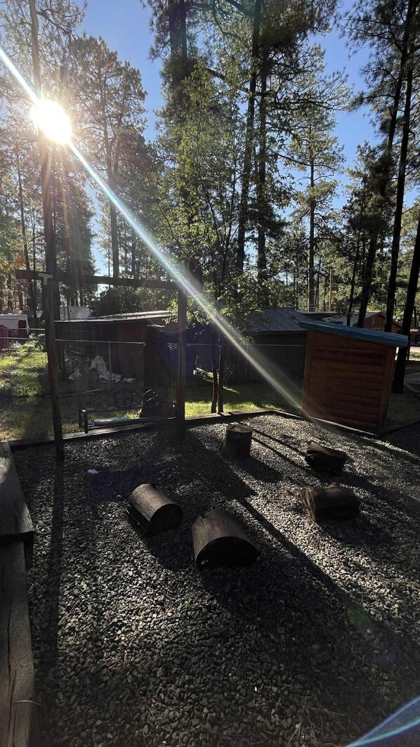 Un camping con una estructura de madera, un área cercada y suelo de grava.