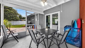 A covered patio with a table and chairs, a ceiling fan, and a view of a backyard. - 3Bed Modern Home Family Friendly Heated Pool (Fort Lauderdale)