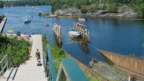 Un río con barcos, un muelle y una pasarela peatonal.