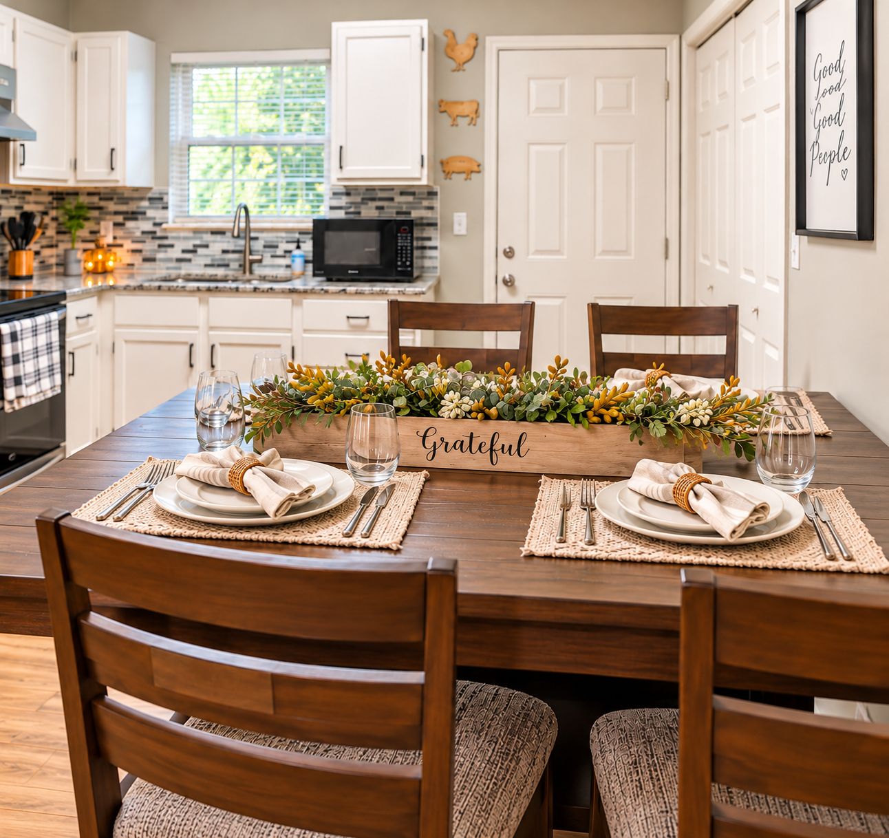 A dining table set with plates, cutlery, and a centerpiece with a 'Grateful' sign.