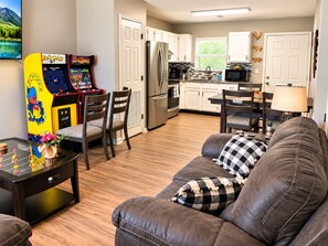 A living room with a sofa, chairs, a coffee table, and a game console. - RARE - 2 miles to Dollywood - Arcades & Much More (Sevierville)