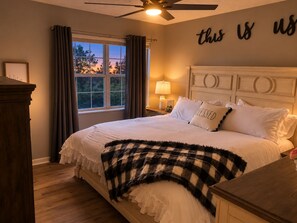 A bedroom with a bed, a nightstand, a window with curtains, a ceiling fan, and a wall with a motivational quote. - RARE - 2 miles to Dollywood - Arcades & Much More (Sevierville)