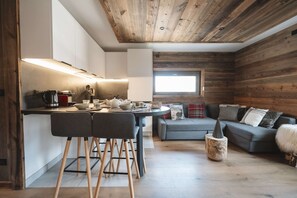 Un ambiente moderno con angolo cottura, zona pranzo e spazio salotto.
