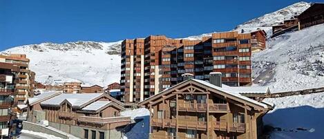 Une station de ski avec des bâtiments en bois et une montagne enneigée en arrière-plan.