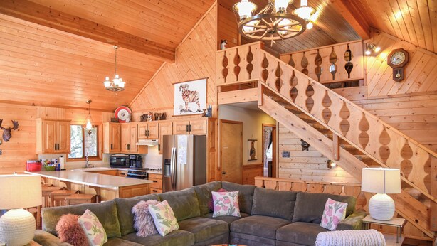 A spacious living area with a large sofa, a dining table, and a kitchen in the background. - Lanna Lasso's the Moon (Red River)