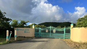 A gated entrance to Spyglass Hill with a sign and a turquoise fence.