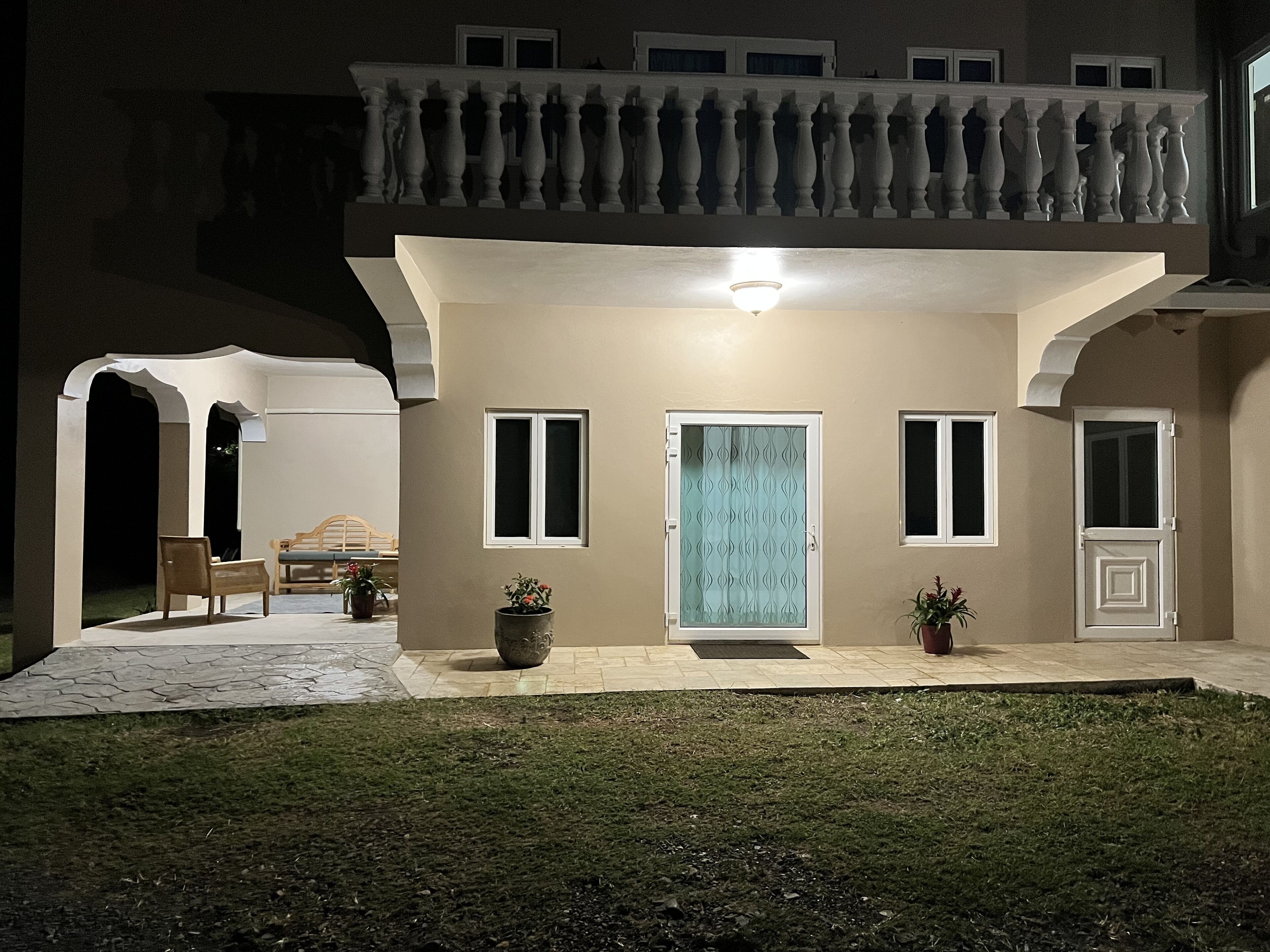 A house with a balcony, a front door, and a small porch area.