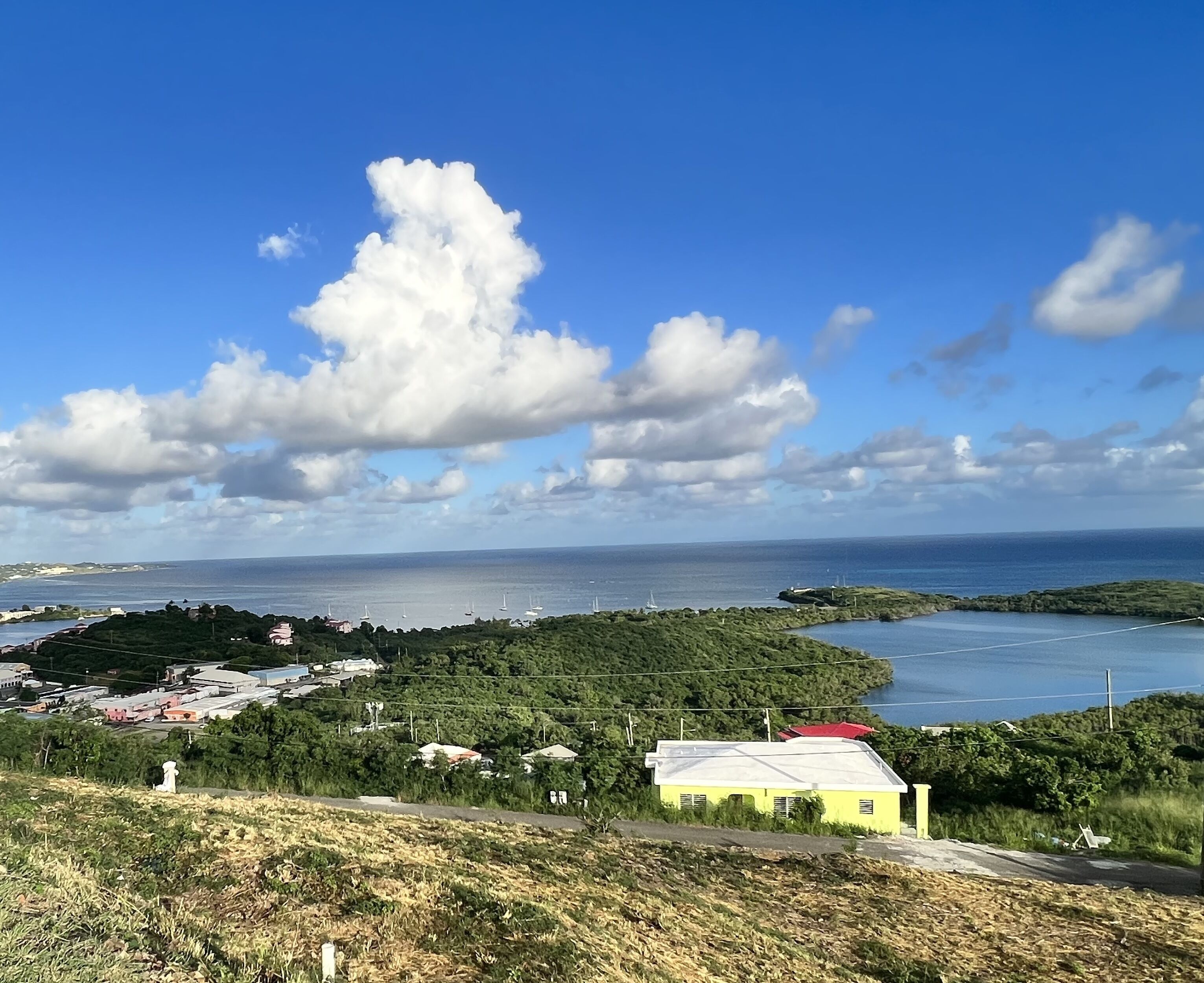 Eine Küstenlandschaft mit Blick auf das Meer, ein kleines Gebäude und verstreute Häuser.