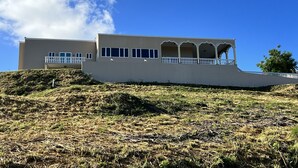 A two-story building with a flat roof and a balcony on the second floor.