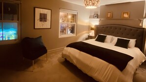 A bedroom with a large bed, a chair, a chandelier, and framed pictures on the wall. - 3 BEDROOM APARTMENT BESIDE THE CASHEL PALACE HOTEL (Cashel)