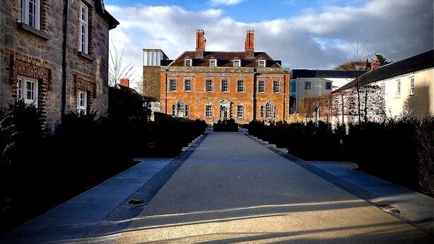 A long, straight street with a large, historic building on the left and a modern structure on the right. - 3 BEDROOM APARTMENT BESIDE THE CASHEL PALACE HOTEL (Cashel)